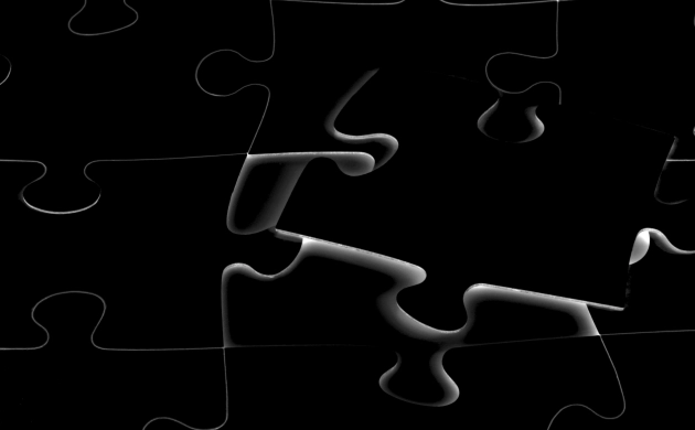 Gros plan sur un puzzle noir et blanc avec une pièce manquante, symbole de recherche ou de connexion.
