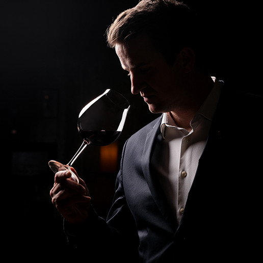 Un homme sentant un verre de vin au restaurant Dans le Noir ?